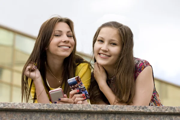 Smiling girls with phones — Stock Photo, Image