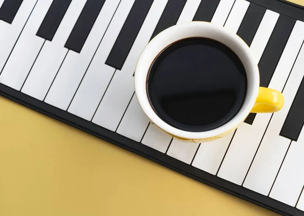 Κίτρινο Κεραμικό Κύπελλο Μαύρο Καφέ Τεθεί Πλήκτρα Πιάνου Παστέλ Φόντο — Φωτογραφία Αρχείου
