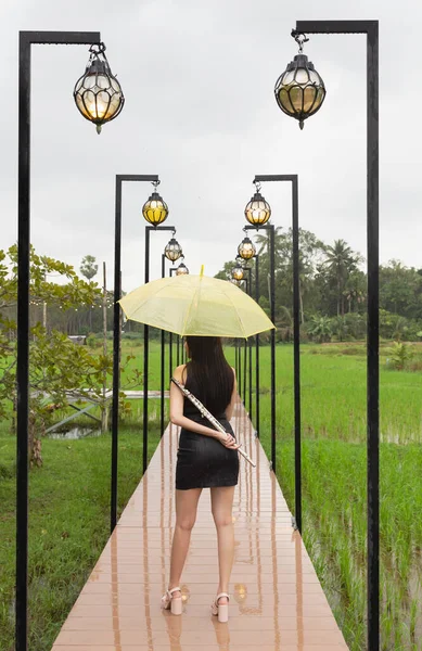 Back Side Woman Holding Flute Yellow Umbrella Hand Standing Wooden — Stock Photo, Image