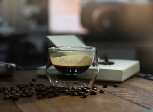 Glas Schwarzen Kaffees Auf Holztisch Gestellt Viele Verschwommene Bohnen Herum — Stockfoto