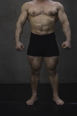 Genç adamın formda ve sıkı vücudu, güçlü kas biçimi egzersizi gösterir.