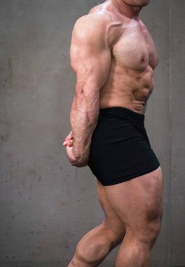Formda ve sağlam vücutlu genç bir adam. Güzel vücut geliştirme kaslarını göstermek için esneme kolu..