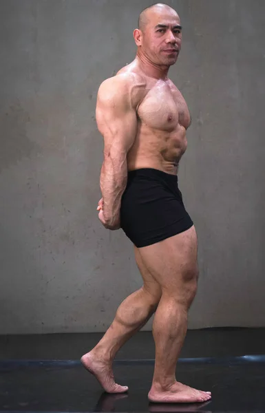 しっかりとした体型の若い男 強い筋肉を示すためにポーズ ボディビルダー — ストック写真