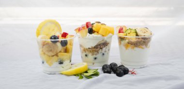 Üç fincan karışık meyveli yoğurt, arka planda, bulanık ışık...