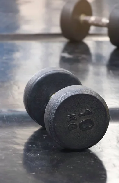 Dumbbell 10 kilograms put on rubber floor,equipment for weightlifting,blurry light around