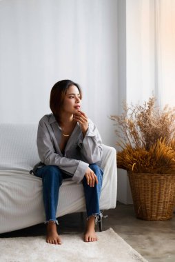 Genç güzel bayan oturma odasında oturuyor, rahatlama zamanı, portre modeli pozu, bulanık ışık...