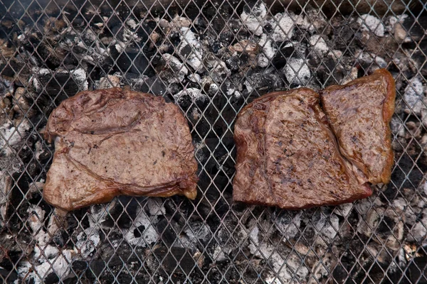 Rumsteak koken op een houtskool barbecue. — Stockfoto