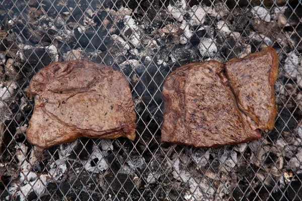 Rump steak cooking on a charcoal barbecue. — Stock Photo, Image