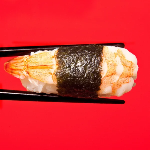 Tenue de sushis avec baguettes — Photo