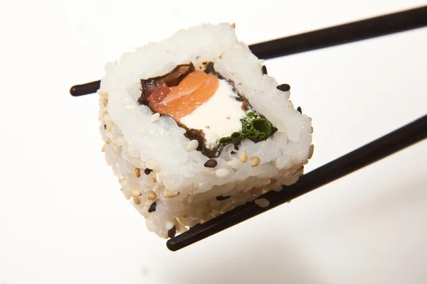 Tenue de sushis avec baguettes — Photo