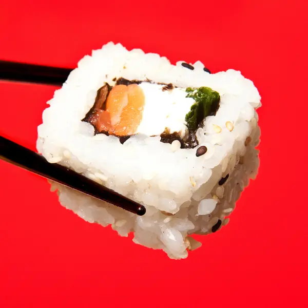 Drží sushi hůlkami — Stock fotografie