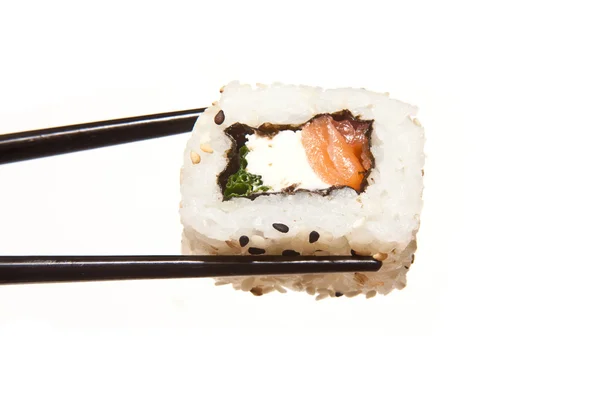 Segurando sushi com pauzinhos — Fotografia de Stock