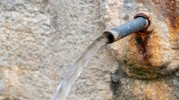 Antik bir doğal taştan akan kaynak suyu.