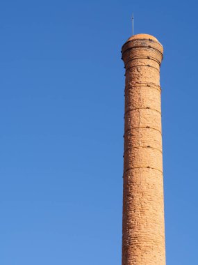 Terk edilmiş eski bir fabrikanın tuğla bacası.