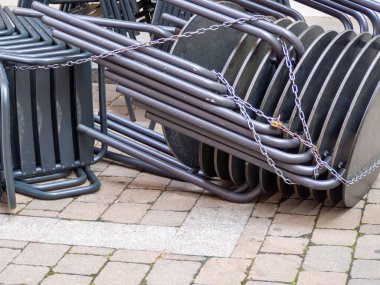 Empty chairs and tables at closed outdoor restaurant for the inflation crisis.
