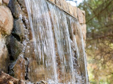 waterfall in an artificial fountain in a public park. Freshness and summer concept High quality photo