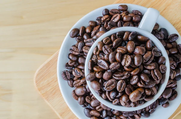 Coffee beans on cup — Stock Photo, Image