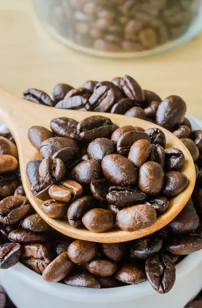 Kaffebønner på skje – stockfoto