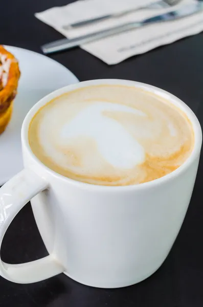 Latte auf dem schwarzen Tisch — Stockfoto