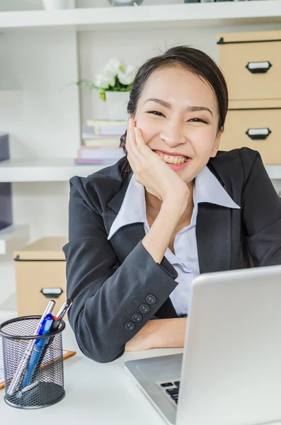 Las mujeres de negocios felices con el ordenador portátil en la oficina —  Fotos de Stock