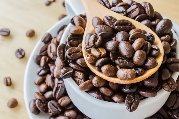 Kaffebønner på skje – stockfoto