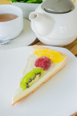 ahşap masa üzerinde beyaz tabak meyve pasta