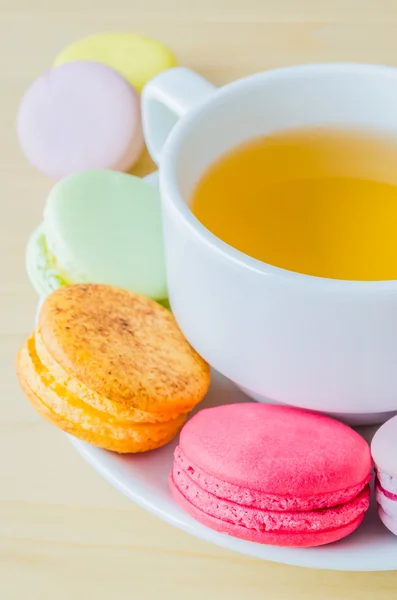 Kolorowe makaronik z białe filiżanka herbaty — Zdjęcie stockowe