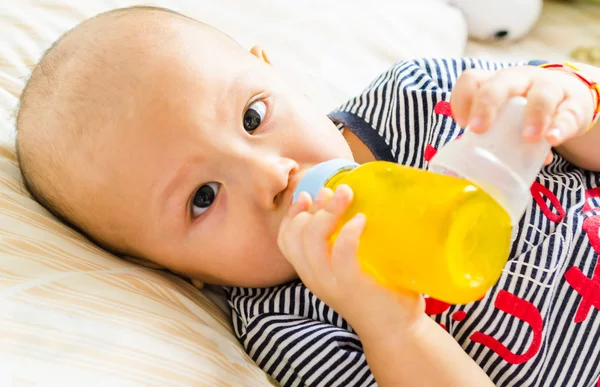 Baby drinking orange juice — Stock Photo, Image