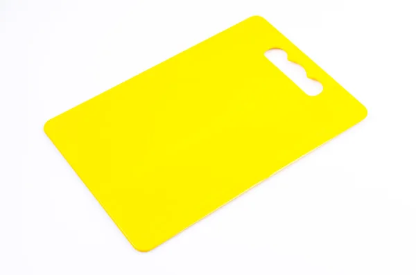 Placa de corte de plástico amarelo no fundo branco isolado — Fotografia de Stock