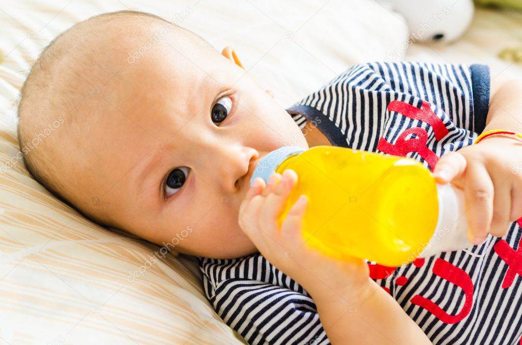 Baby drinking orange juice — Stock Photo © mrsiraphol 37700849