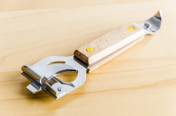 Консервный нож на деревянном фоне — стоковое фото