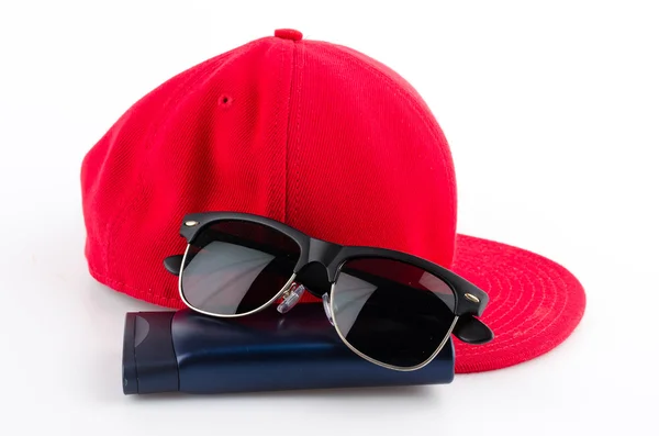Rode pet, zonnebril en lotion — Stockfoto