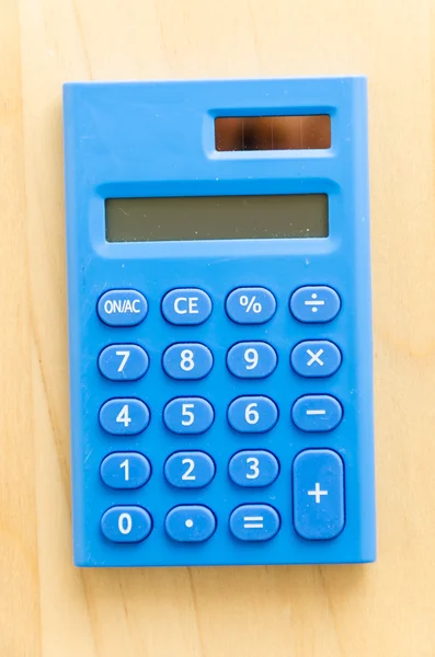 Калькулятор на деревянном столе — стоковое фото