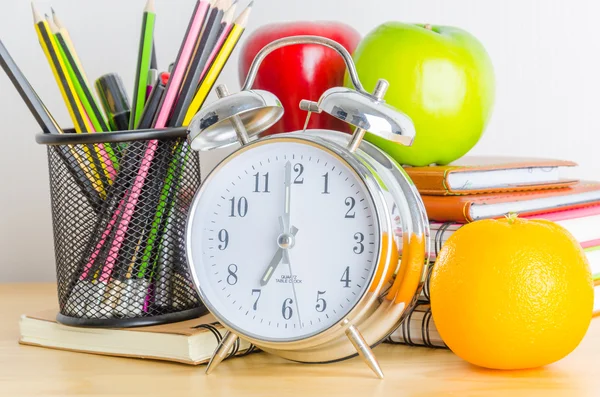 Poznámka: knihy, hodiny, tužky, jablka na stůl — Stock fotografie