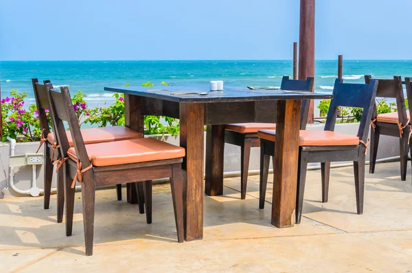 Mesa de jantar e cadeiras na praia — Fotografia de Stock