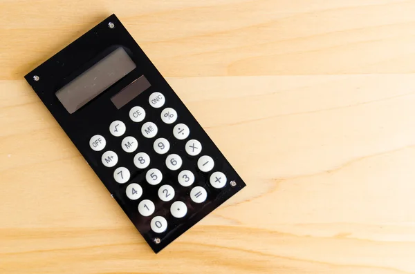 Kalkulačka na dřevěný stůl — Stock fotografie