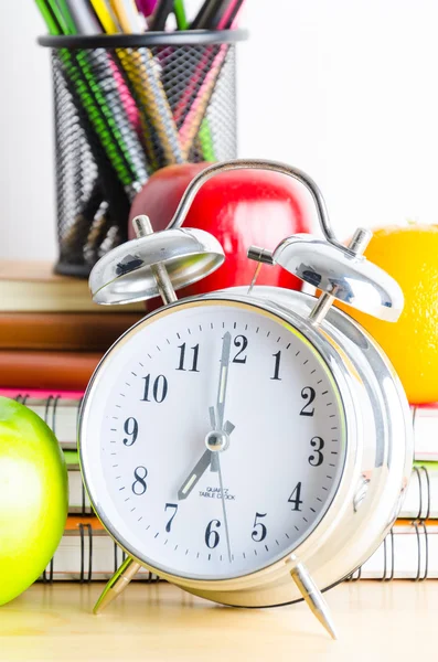 Note books , clock , pencils , apples