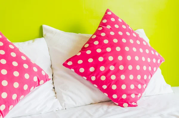 Travesseiro de polca colorido na cama branca — Fotografia de Stock