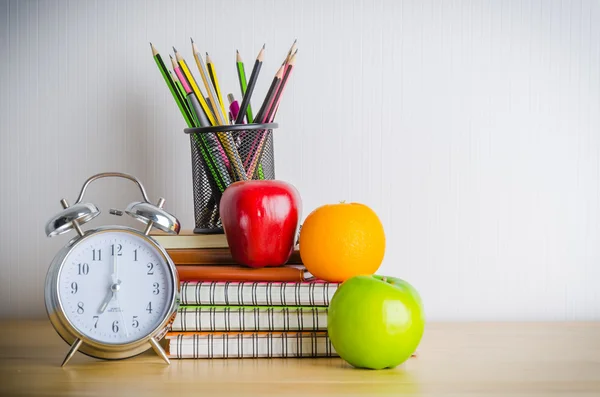 Tillbaka till skolan, notera bokar, klocka, penna, äpple på trä tabl — Stockfoto