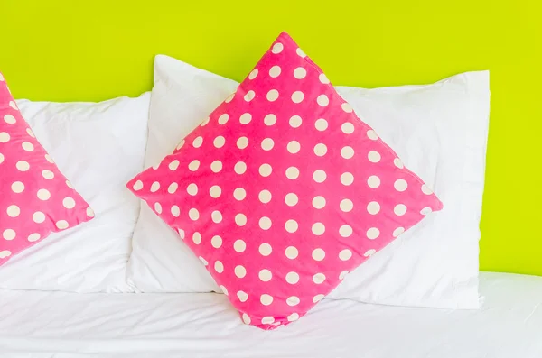 Красочная полька подушка на белой кровати — стоковое фото