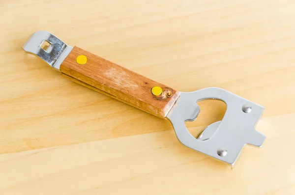 Can opener on wood background — Stock Photo, Image