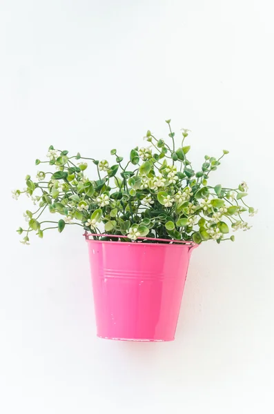 Z tworzyw sztucznych kwiatów w wazonie na tle ściany — Zdjęcie stockowe