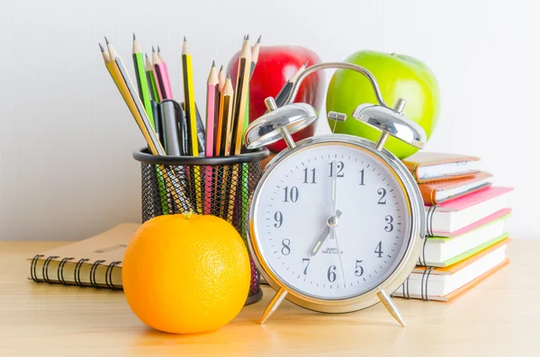 Tillbaka till skolan, notera bokar, klocka, penna, äpple på trä tabl — Stockfoto