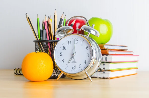 Regreso a la escuela, cuaderno, reloj, lápiz, manzana sobre tabla de madera — Foto de Stock