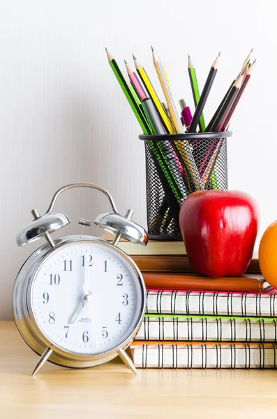 Ritorno a scuola, taccuino, orologio, matita, mela su tavola di legno — Foto Stock