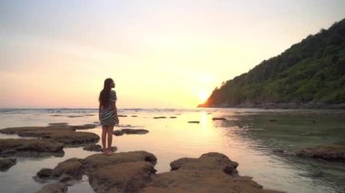 Yaz tatilinde deniz kıyısındaki Asyalı kadının görüntüleri.