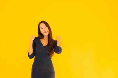 İzole edilmiş sarı arka planda hareketli güzel Asyalı kadın portresi.