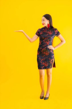 Güzel bir portre genç Asyalı kadın Çin 'in yeni yıl konsepti için sarı izole edilmiş arka planda Çin elbisesi giyiyor.