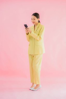 Güzel Asyalı iş kadını portresi. Arka planda kahve fincanı ve akıllı cep telefonu kullanıyor.