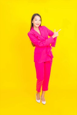 Güzel bir Asyalı kadın sarı arka planda gülümsüyor.